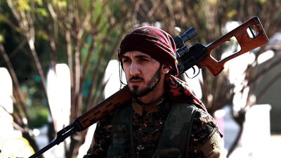 A fighter from the Syrian Democratic Forces (SDF) stands in a cemetary during battles against the Islamic State (IS) group. AFP