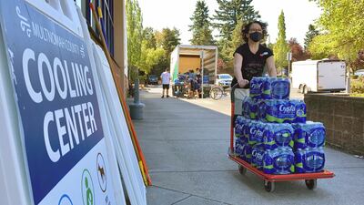 A volunteer unloads bottled water at a cooling center established to help vulnerable residents ride out a dangerous heat wave on August 11, 2021, in Oregon. AP