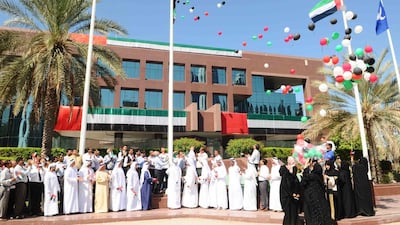 Emarat employees raise the UAE flag at its head office in Dubai. Courtesy Emarat.