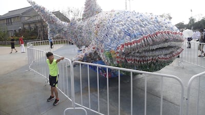 A boy poses with a 9.1-metre-long whale made of 40,000 abandoned plastic bottles for a photo at Rizhao Ocean Park. Getty