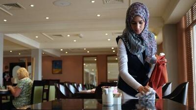 They also serve who stand and wait: an Omani student working as a waitress during an internship at a local Muscat hotel.