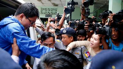 Reuters reporter Wa Lone's wife Pann Ei (2nd-R) tries to catch his hand as he arrives at court in Yangon, Myanmar, on December 27, 2017. Reuters