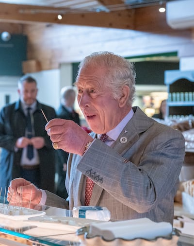 The Prince of Wales tastes some cheese during a tour in Penrith, Cumbria. Getty Images.