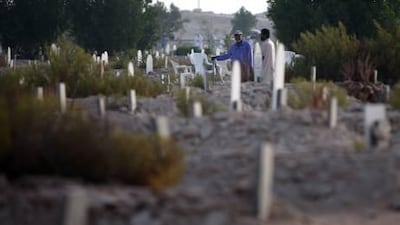 Relatives visit graves of their loved ones at the Bani Yas Cemetery. Now a new cemetery there has been designed for non-Muslims.