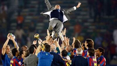 Barcelona players throw coach Pep Guardiola in the air to celebrate the Club World Cup here in Abu Dhabi last year.