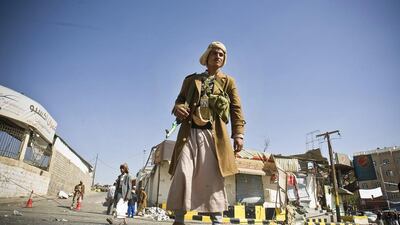 A Houthi militant stands guard in front of a building damaged during recent clashes near the presidential palace in Sanaa on January 20. Hani Mohammed / AP Photo