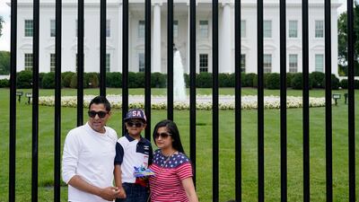 People pose for photos on a section of Pennsylvania Avenue that was reopened to the public in front of the White House in Washington, DC.
