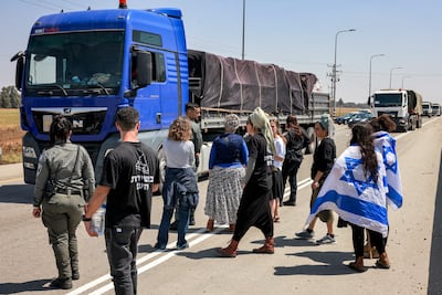 A lorry passes right-wing demonstrators as they attempt to block humanitarian aid from entering Gaza at the Karam Abu Salem crossing between Israel and Gaza. AFP