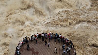 People watch the flooded Jinsha River at a sightseeing platform of Tiger Leaping Gorge, in Diqing, Yunnan Province, China. Reuters / Stringer