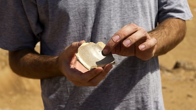 Tim Power, archaeologist and professor at Zayed University holds an estimated 1000 year old pottery shard, found on the surface during the shoot, at the site of a Oman-UAE joint archaeological project un-earthing remains of an early Islamic settlement, 9th century, which they believe represents the remains of the lost city of Tawam near the border with the UAE in Buraimi on September 12, 2015. Christopher Pike / The National