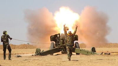 Popular Mobilization Forces personnel fire artillery during clashes with ISIL south of Mosul. Reuters