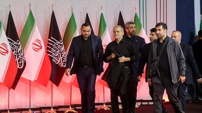 Mr Pezeshkian, centre, arrives at the ceremony in Tehran. Reuters