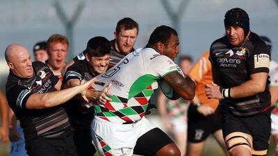 Jean Boates, right, and his Abu Dhabi Saracens teammates attempt to tackle Willie Umu of Abu Dhabi Harlequins. Photo Courtesy / West Asia Championship