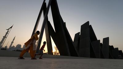 Visitors walk at the courtyard of the memorial of Wahat Al Karama opposite to Sheikh Zayed Mosque in Abu Dhabi. EPA