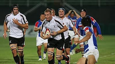 Michael Cox-Hill, centre, runs through the Korean defence during the Gulf's last ever match on Friday. Under the IRB's new laws, players can only represent their country of residence.