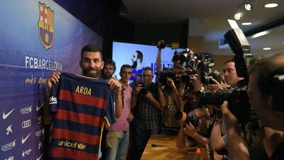 Arda Turan shows off his Barcelona shirt at his official presentation. Lluis Gene / AFP