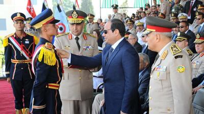 A handout picture released by the Egyptian Presidency on June 24, 2014 shows Egypt's president Abdel Fattah al-Sisi, right, honouring a recruit during a military graduation ceremony in the capital Cairo. Me EL Sisi has pledged to give up half his pay to help boost Egypt's economy. AFP Photo