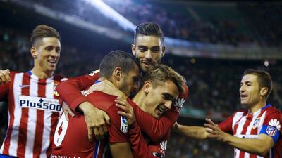 Koke, centre, is congratulated by his Atletico Madrid teammates after scoring the winning goal against Real Betis. Marcelo del Pozo / Reuters