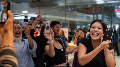 Apple customers show their delight after becoming among the first to buy the iPhone Duo, in Kuala Lumpur, Malaysia. Getty Images