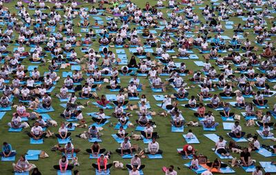 People practice yoga in Abu Dhabi on June 21, 2022. AP