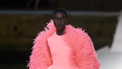 A puffball-skirted dress in flamingo pink is teamed with feathers of salmon pink at the Valentino autumn 2021 haute couture show