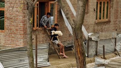 Kashmiri men evacuate a sheep from a flooded house in Srinagar. Mukhtar Khan / AP Photo