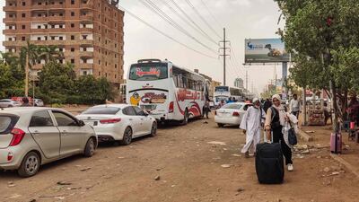 People board a bus leaving Khartoum as battles between military factions rage in the city. AFP