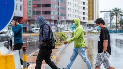 Many people were wearing warm clothes, as chilly temperatures accompanied the rains. Victor Besa / The National