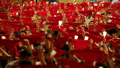 Revellers hold up red scarves and candles in the traditional end to the San Fermin festival, in Pamplona, Spain. Reuters