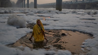 A Hindu worshipper performs rituals in the River Yamuna, which is covered by chemical foam caused by industrial and domestic pollution, during the Chhath Puja festival in New Delhi, India. AP