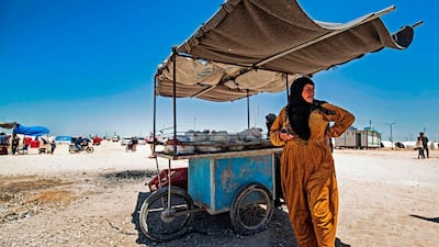 A displaced Syrian woman next to her cart, selling chicken, at the Washukanni camp for the internally displaced in Syria's northeastern Hasakeh province on May 10, during Ramadan. Delil Souleiman / AFP