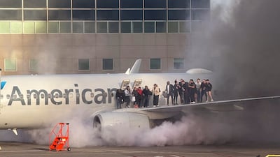 Passengers are evacuated onto the wing of an American Airlines plane after it caught fire in Denver, Colorado. AFP