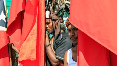 East Timorese men hold national flags during a ceremony to mark 45th anniversary of Independence Restoration Day in Liquica, East Timor. EPA
