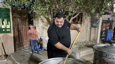 Safa Jabbar Karim, 34, stirs a vat of meat. He says the community raised about 1.75 million Iraqi dinars ($1,200) for the food. Sinan Mahmoud / The National