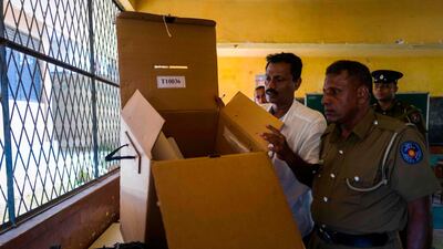 A policeman and an electoral offical check a ballot box at a polling station in Colombo on November 15, 2019. AFP