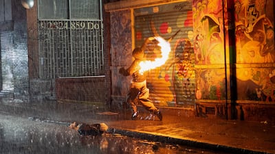A demonstrator throws a Molotov cocktail during clashes with police, after a protest in Bogota against Colombia's President Abelardo de la Espriella turned violent. AFP