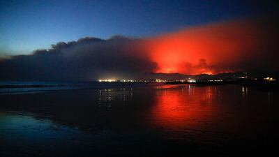 A wildfire continues to burn as its red glow is reflected on the beach in Ventura, California. Jae C Hong / AP Photo
