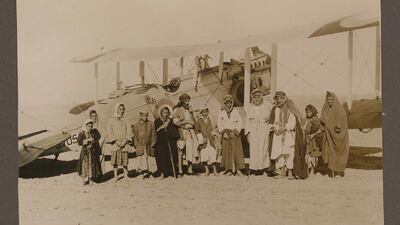 Iraq and Kurdistan - compiled by an RAF serviceman. A group portrait of several men and children pose in front of an airplane in Iraq, circa 1936-1938