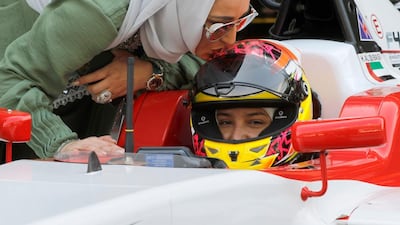 Hamda Al Qubaisi receives a kiss on the helmet from her mother, Kawthar, ahead of the race. Victor Besa / The National
