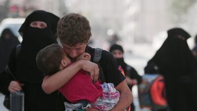 A civilian carries a child as he walks with others after they were evacuated by the Syria Democratic Forces (SDF) fighters from an ISIL-controlled neighbourhood of Manbij, in Aleppo Governorate, Syria. The SDF has said ISIL was using civilians as human shields. Rodi Said / Reuters