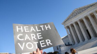 A demonstrator holds a sign in front of the US Supreme Court in Washington as the high court opened arguments in the long-running case over Affordable Care Act. AFP