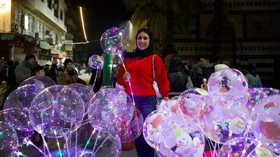 A woman buys an LED balloon to ring in the new year. Getty images