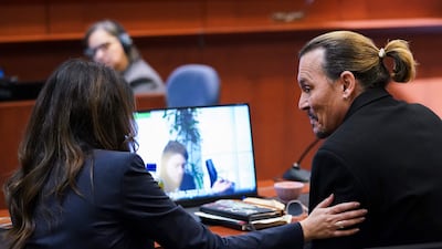 Depp speaks with his lawyer Camille Vasquez. AFP