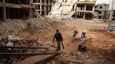A Syrian rebel-fighter from the National Liberation Front (NLF) enters a building in the rebel-held Al Rashidin district of western Aleppo's countryside. AFP