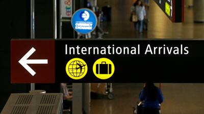 Travellers walk near a sign for international arrivals at Seattle-Tacoma International Airport on June 26, 2017. Ted S Warren / AP Photo