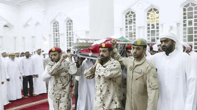 Men carry the body of Warrant Officer Sameer Mohammed Murad Abu Bakr into a mosque in Ajman before performing funeral prayers on Saturday. Wam