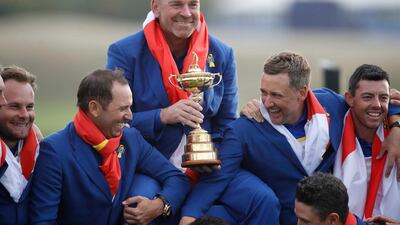 Team Europe captain Thomas Bjorn holds the trophy as they celebrate. Reuters