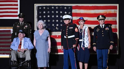 Retired US Marine Corps veterans appear on stage with their families, as US President Donald Trump speaks. AFP