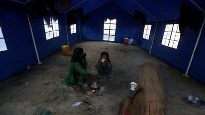 Flood victims drink tea at the UNHCR camp in Sukkur. AP