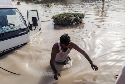 A man attempts to salvage his truck in Dubai Investments Park after the 2016 storm. Alex Atack for The National